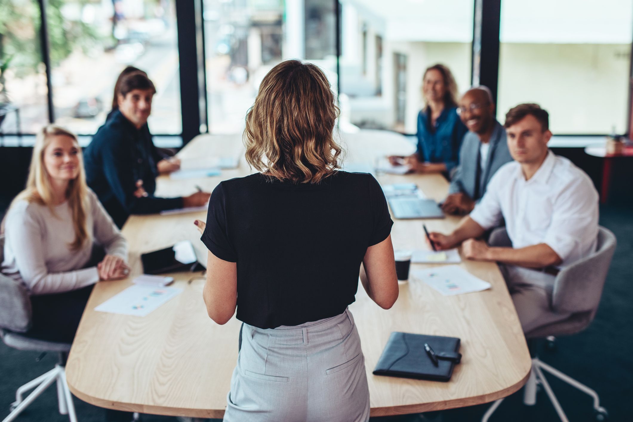 A young woman presents a workplace violence prevention and intervention plan to her company's board.